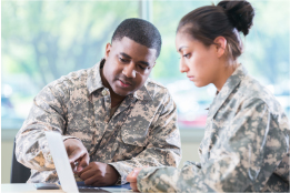 two servicepeople in uniforn in front of a computer