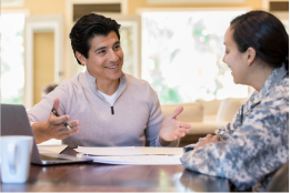 two people talking at a desk